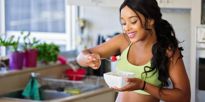 woman eating strawberry in the kitchen