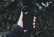 hand holding cellphone with fisheye lens