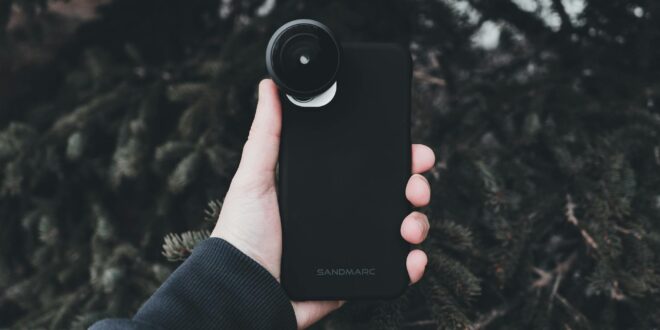 hand holding cellphone with fisheye lens