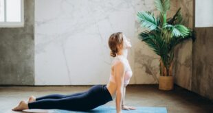 woman in pink sports bra and black leggings doing yoga on yoga mat