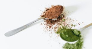 close up shot of spoons with colored powders on a white surface