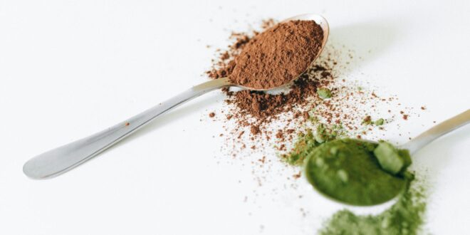close up shot of spoons with colored powders on a white surface