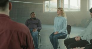 woman in blue long sleeve shirt sitting beside man in black jacket