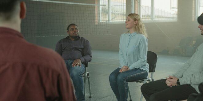 woman in blue long sleeve shirt sitting beside man in black jacket