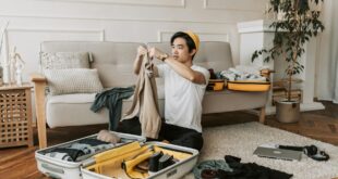 a man packing clothes in a suitcase